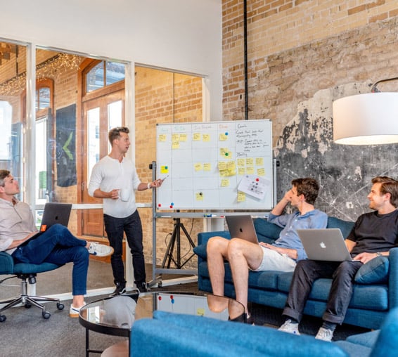 Business team collaborating in office meeting showing teamwork, company culture, and professional IT service environment.